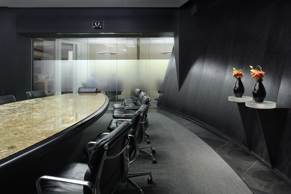 A view of a dark conference room with ebony walls.