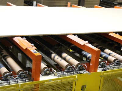 A shot of a panel moving down the line. A series of round rollers is visible under the panel.